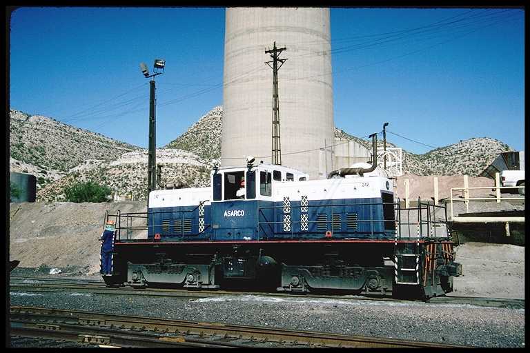 Center cab diesel at ASARCO smelter.  Round structure behind locomotive is base of the smoke stack.