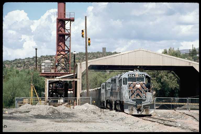 Ore train dumping ore.  Stoplight is used to control train speed over the dump chute.