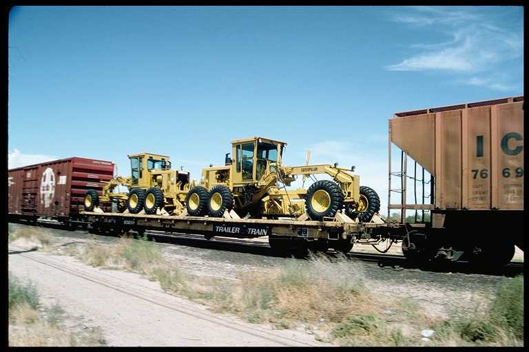 Flat car with load of construction equipment.