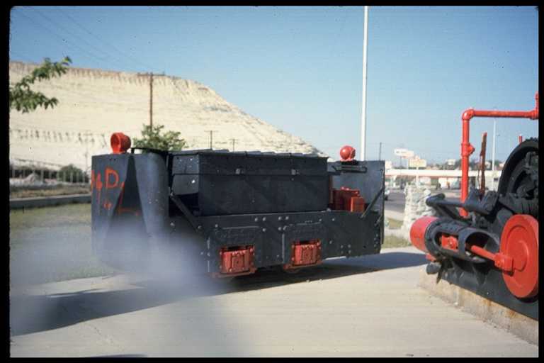 Photo of mining locomotive on display with other mining equipment.