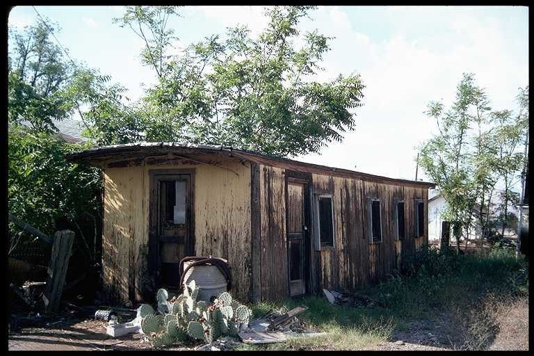 Abandoned passenger car used as storage shed.